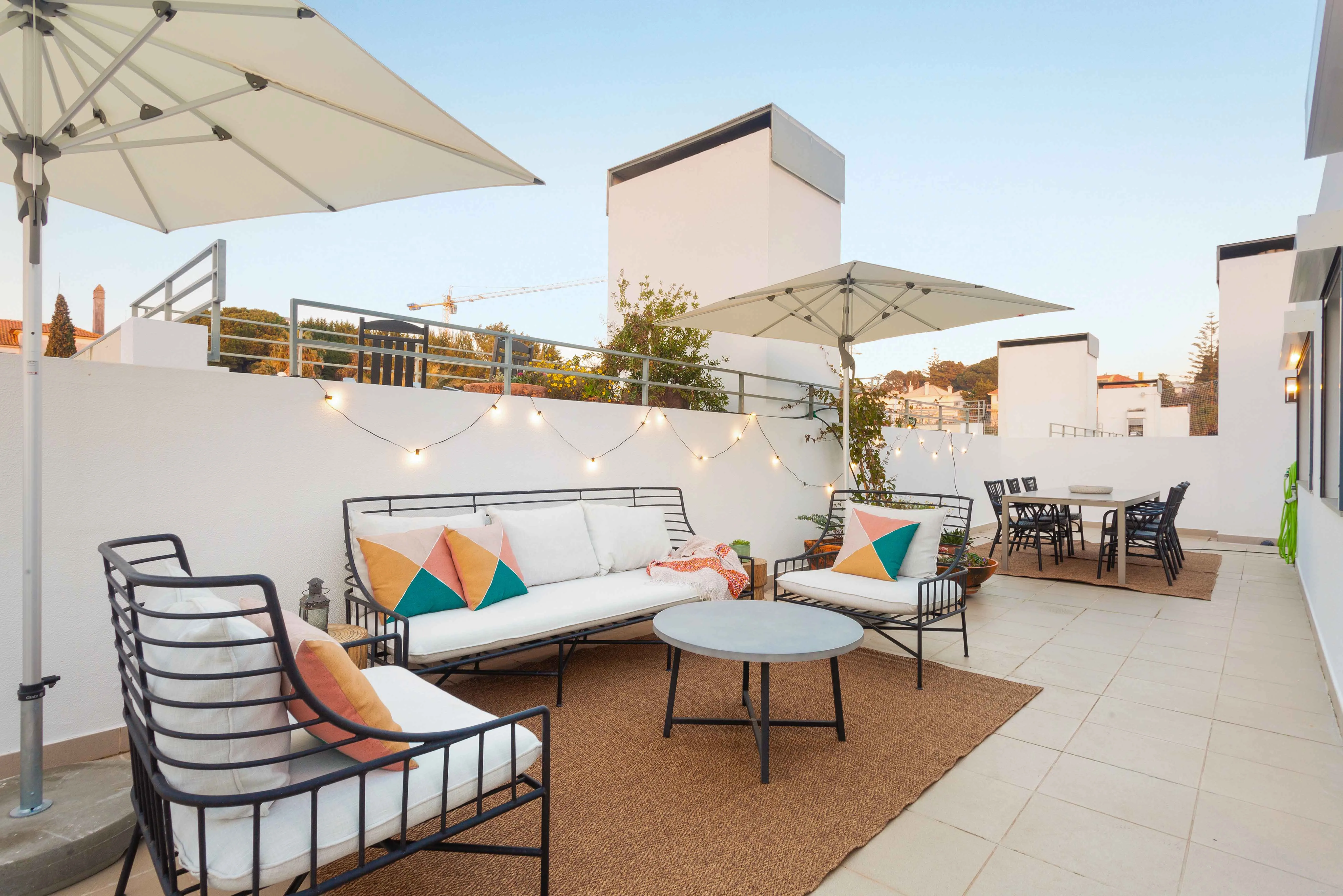 Terraço de 120 m² com luzes suspensas — moradia Riviera Cascais pela Maya's Homes